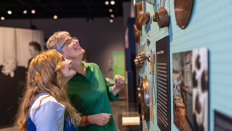 Visitors looking at cooking tools at the Julia Child Exhibit.